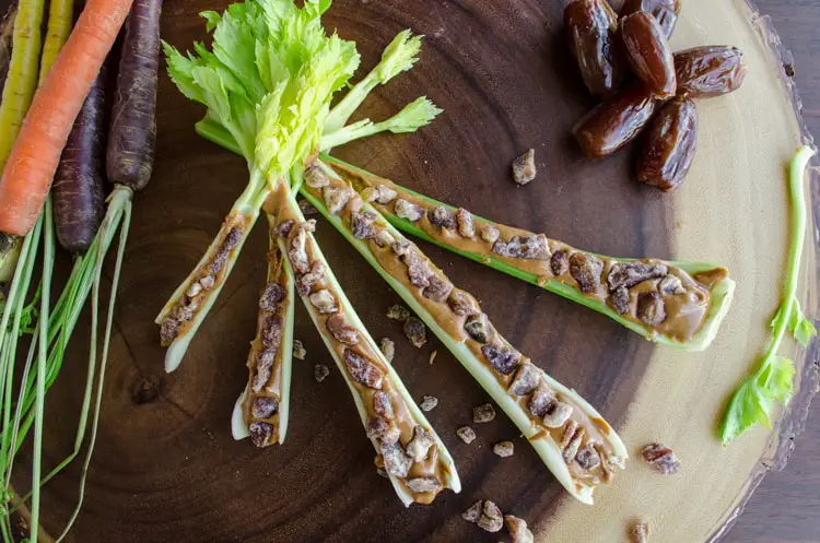 Looking down on an array of celery filled with peanut butter and dates to make Ants on a Log.