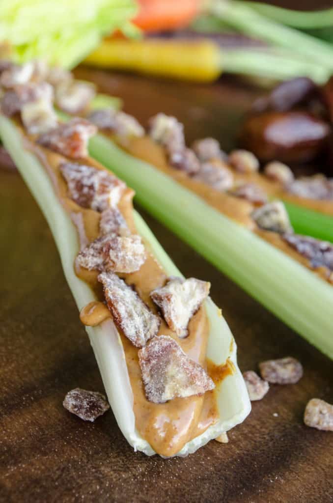Green celery filled with peanut butter and dried date pieces.