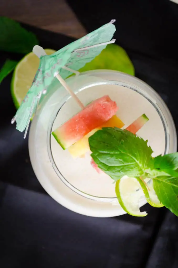 Crowd Pleasing Coconut Lime Mocktail is delicious, especially when garnished with fresh fruit and mint leaves.
