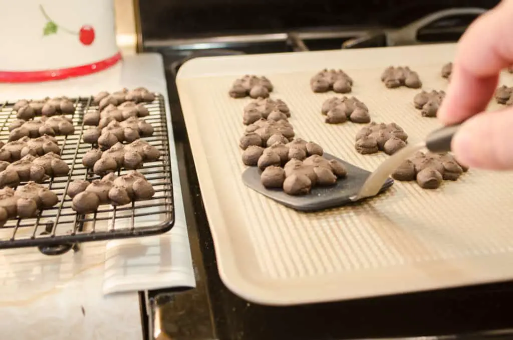 Removing Chocolate Cinnamon Bear Cookies with an OXO silicone cookie spatula to cool on a cooling rack.