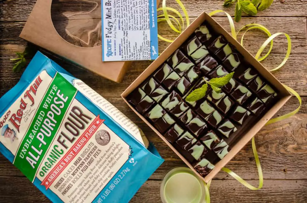 Fudgy Mint Brownies in a gift box with the top off next to a bag of Bob's Red Mill All-Purpose Organic Flour.