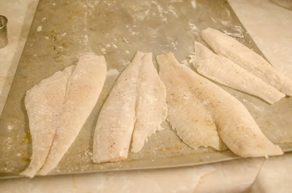A baking sheet with breaded raw fish ready to be made into Fast Fish Dinner with Herbed Browned Butter.