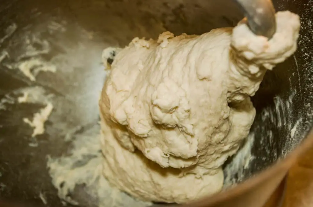 A cose-up of dough around a dough hook in a stand mixer for Quick Crusty Dinner Bread.