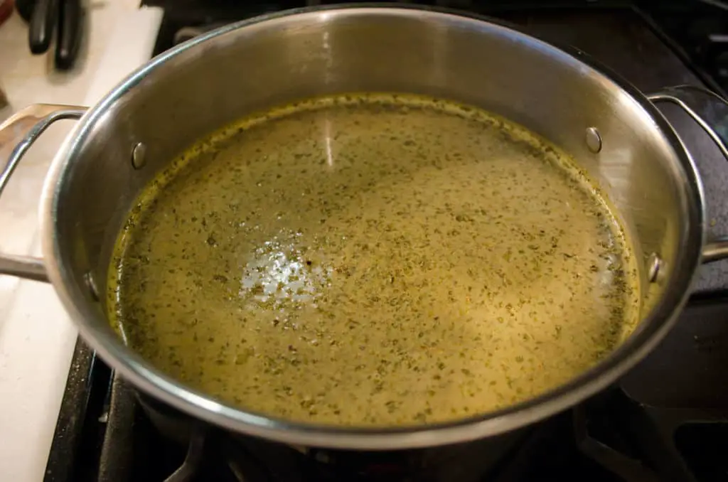 A close up of seasoned broth for Meatless Monday Vegetable Rotini Soup sits on the stovetop.