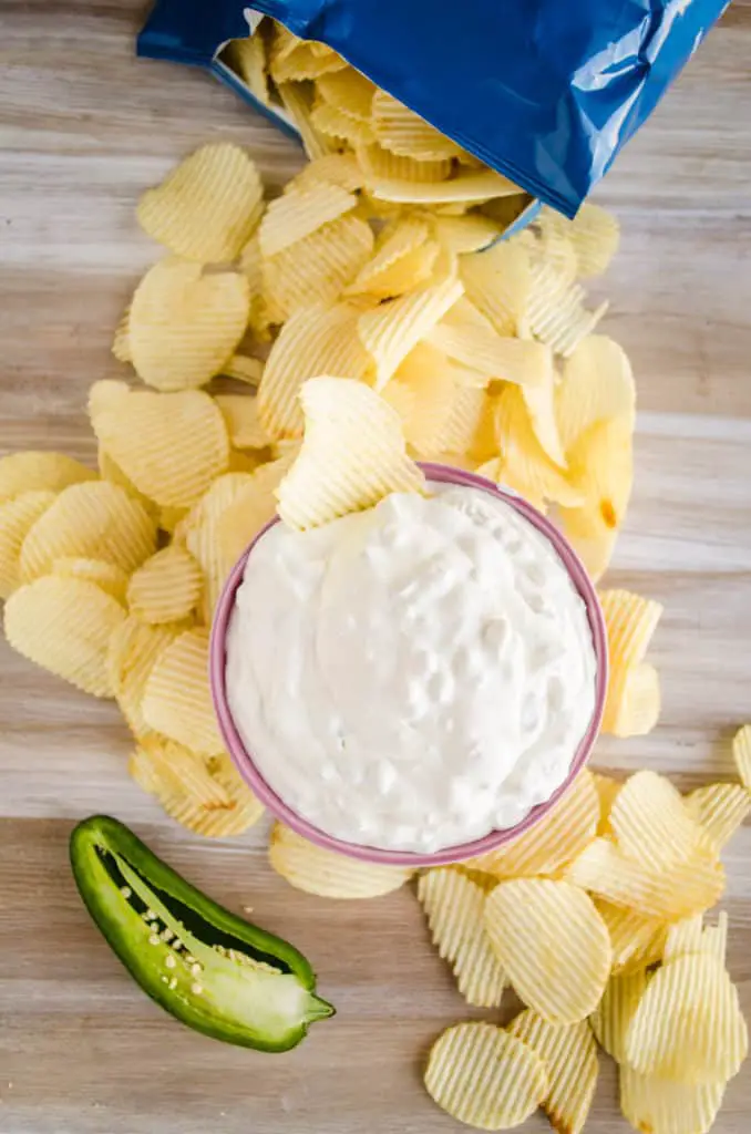 A bowl of Copycat Creamland Green Chile Dip picture from above surrounded by potato chips - The Goldilocks Kitchen