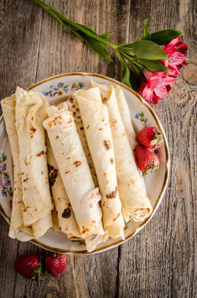 Looking down on a plate full or rolled Norwegian Lefse ready to be eaten - The Goldilocks Kitchen