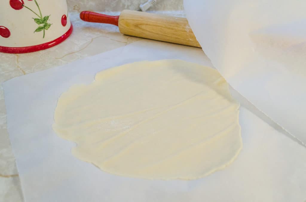 A raw Norwegian Lefse round sits on a piece of parchment paper - The Goldilocks Kitchen