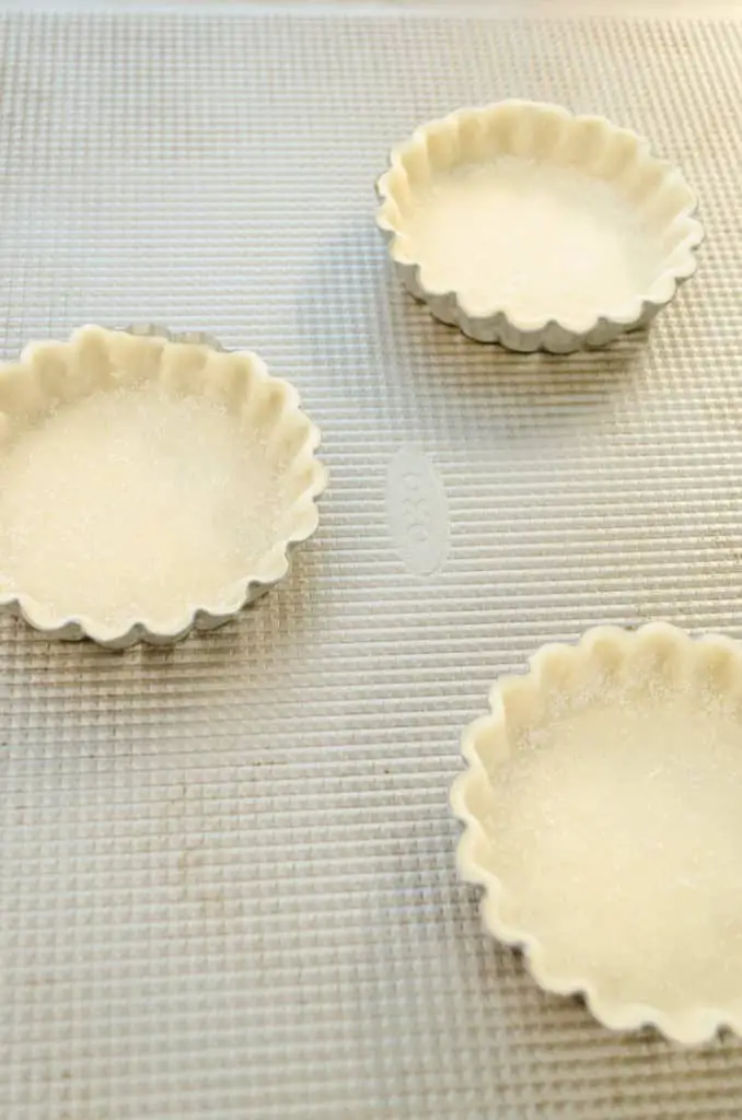 Mini-tart pans filled with pre-made dough for Fruit Tartlets - the Goldilocks Kitchen