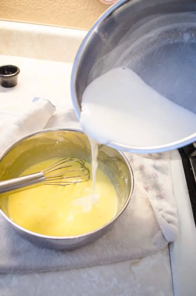 Simmering half and half is slowly poured into an egg yolk mixture to temper for pastry cream to fill Fruit Tartlets - The Goldilocks Kitchen