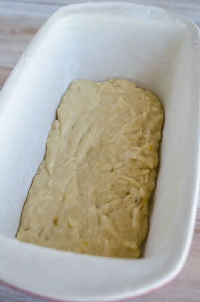 A thin layer of Banana Bread batter is spread into the bottom of a loaf pan. - The Goldilocks Kitchen