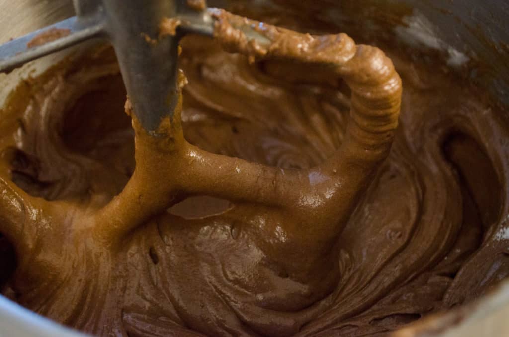 A close up of chocolate batter in a stand mixer for Chocolate Raspberry Bundt Cake. - The Goldilocks Kitchen