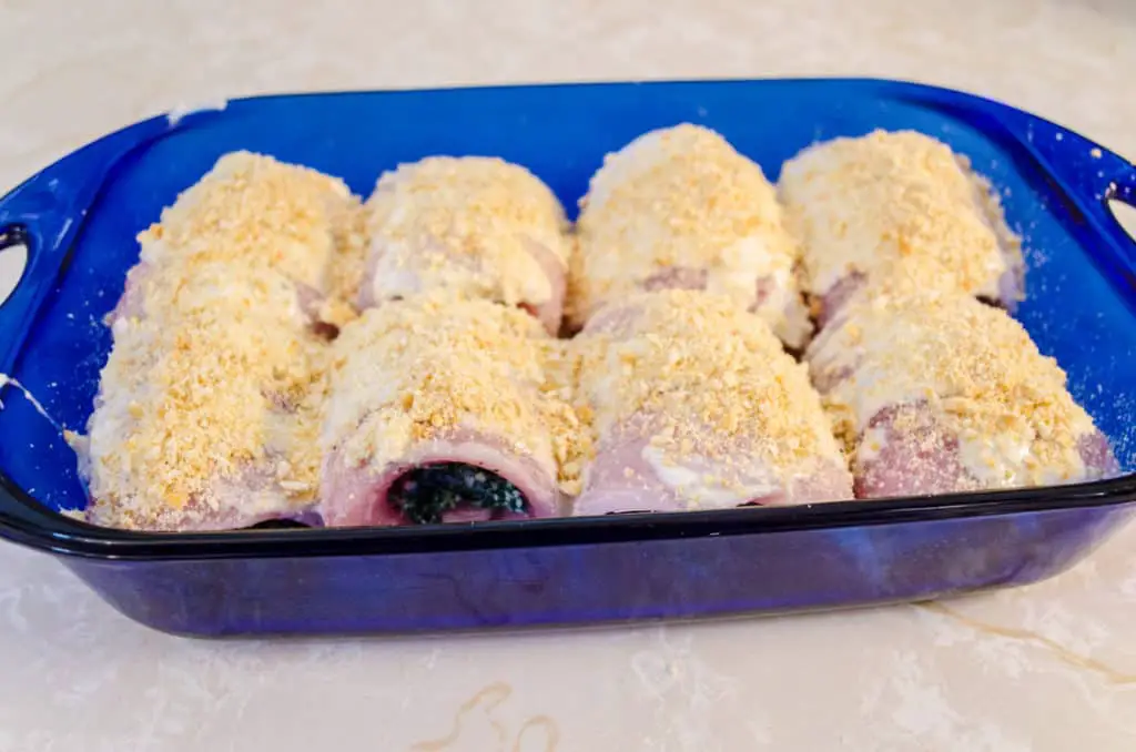 Stuffed fish bundles in a blue baking dish are topped with crushed Ritz crackers for a nice crunchy crust on Creamy Stuffed Fish Florentine - The Goldilocks Kitchen