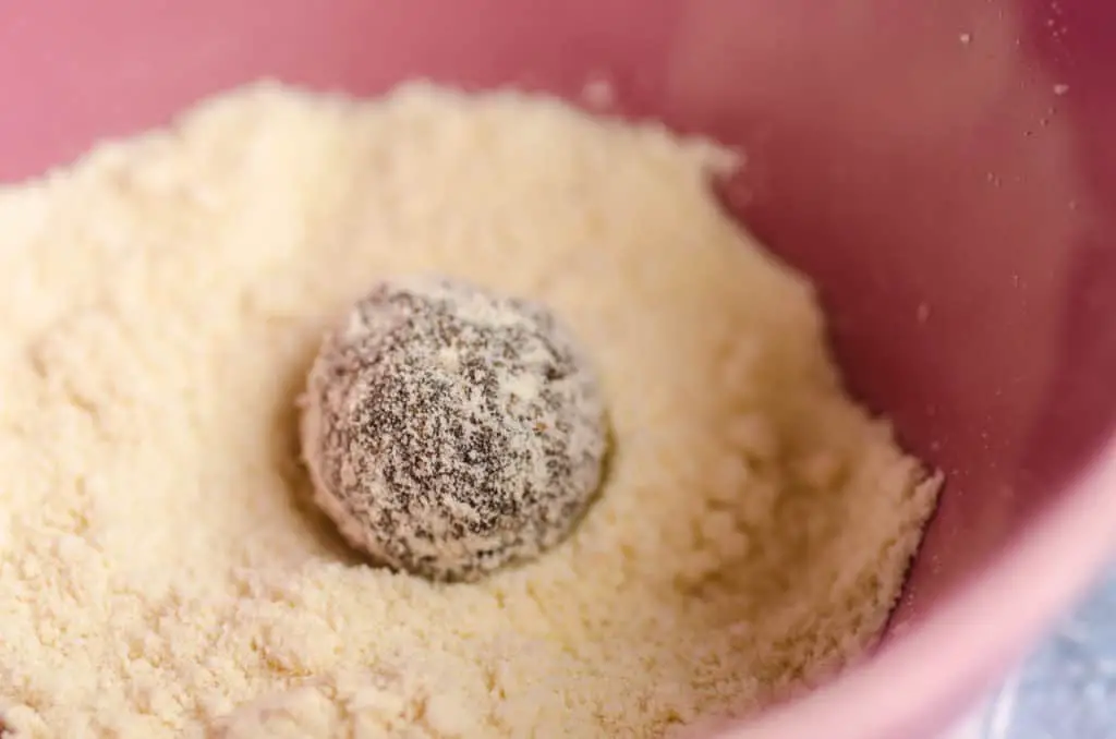 A Chocolate Mint Energy Bites ball is rolled in coconut flour - The Goldilocks Kitchen