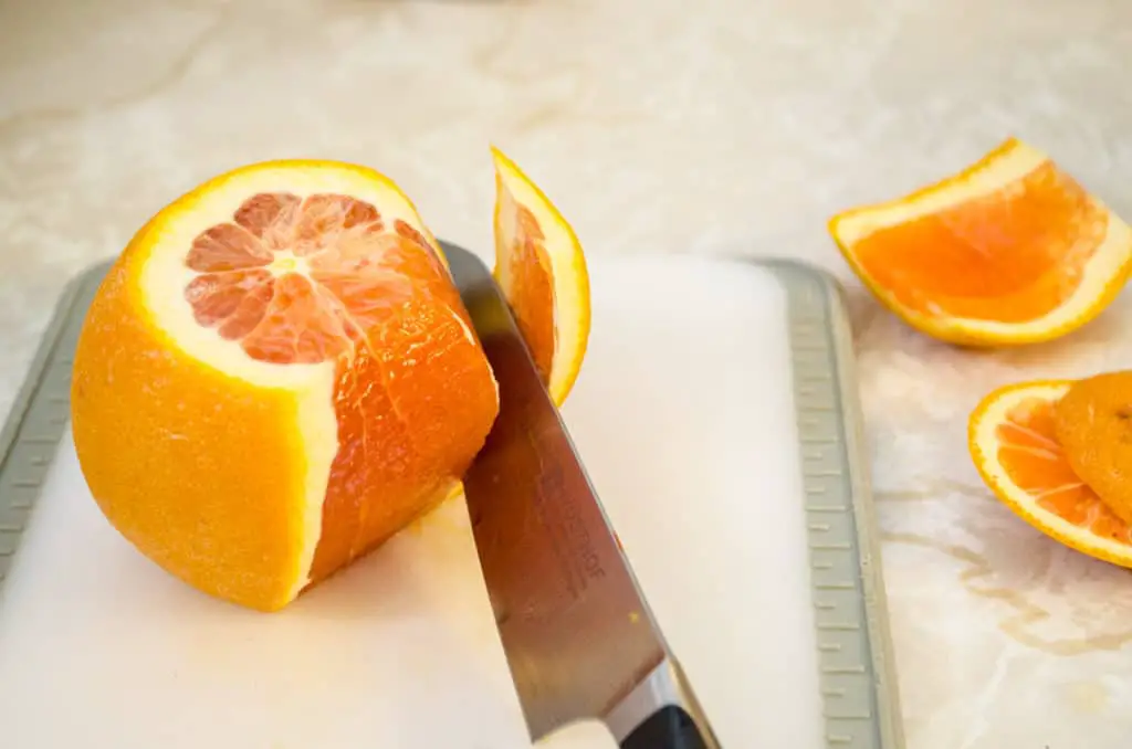 Orange peel is sliced off with a knife for Feta Citrus Salad - The Goldilocks Kitchen