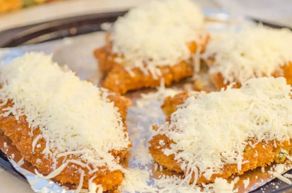 Freshly fried Easy Chicken Parmesan pieces are topped with mozzarella cheese and broiled to melt it.
