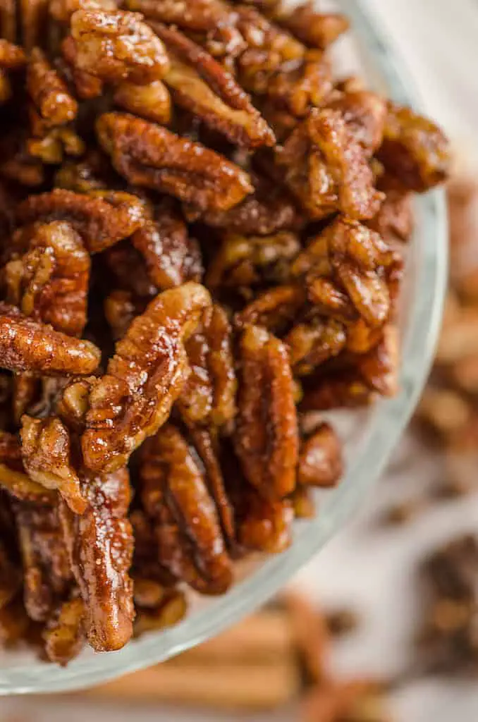 A close up picture of Candied Spice Pecans in a glass bowl - The Goldilocks Kitchen