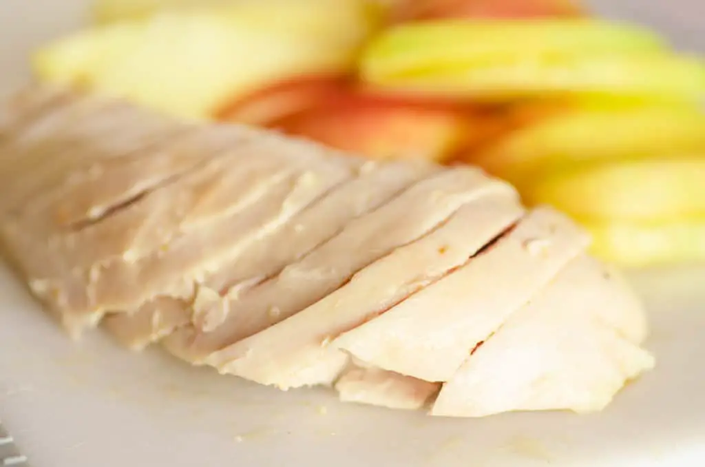 Rotisserie Chicken breast sits sliced on the bias ready for Apple Cheddar Salad.. - The Goldilocks Kitchen