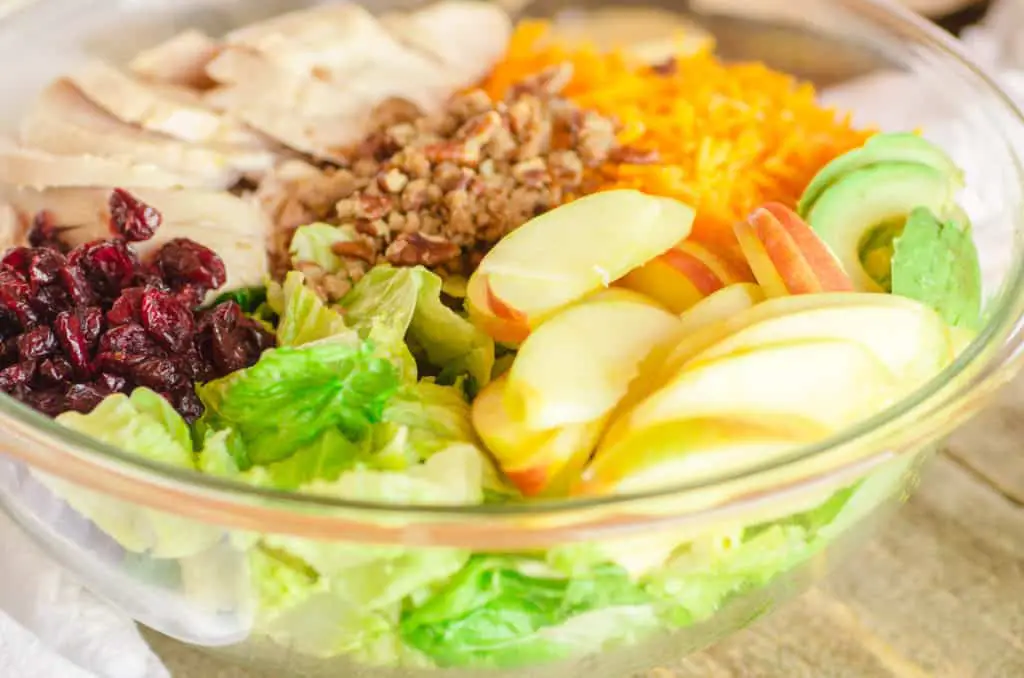 Chicken Apple Cheddar Salad ingredients sit partitioned in a large glass bowl. - The Goldilocks Kitchen