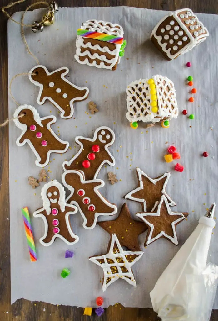 Easy Gingerbread Cookies shaped like gingerbread men, women, stars and mini-houses, are all decorated with white frosting and candy. - The Goldilocks Kitchen