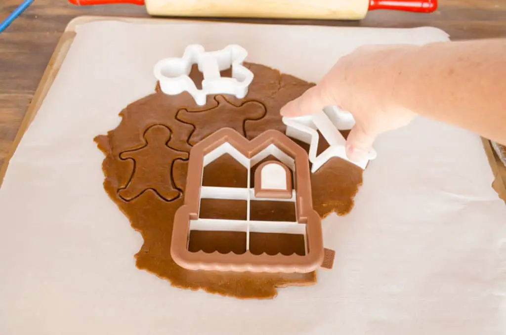 Cookie cutters are used to cut shapes out of rolled out Easy Gingerbread Cookies dough- The Goldilocks Kitchen