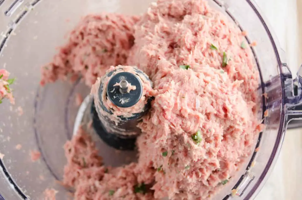 Processed meats and minced fresh parsley fill a food processor bowl for Meatloaf - The Goldilocks Kitchen
