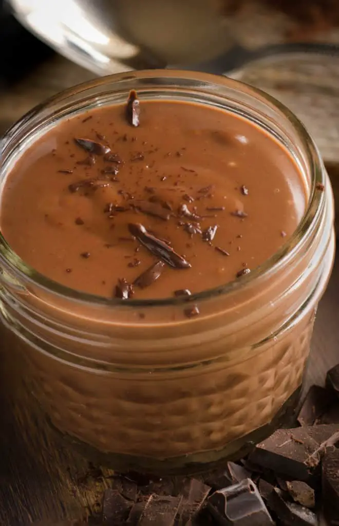A small decorative mason jar full of Homemade Chocolate Pudding, sprinkled with chocolate shavings on top - The Goldilocks Kitchen