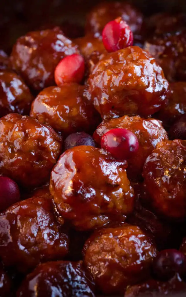 A close up picture of Cranberry Ginger Meatballs garnished with fresh cranberries - The Goldilocks Kitchen