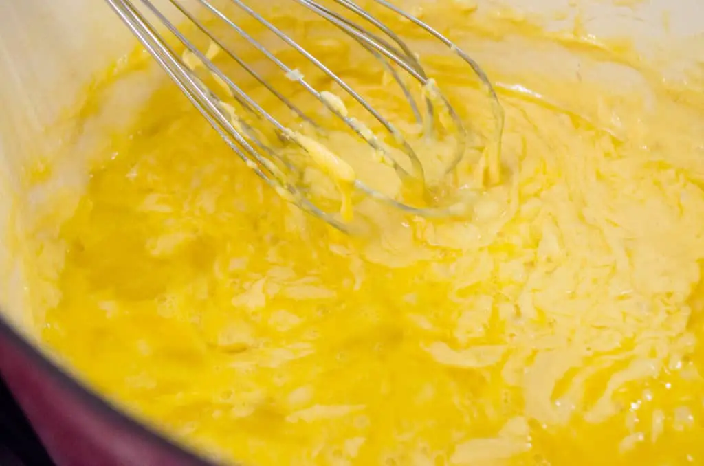 Three eggs are whisked into a cheesy sauce to make Cheesy Cauliflower Broccoli Bake - The Goldilocks Kitchen