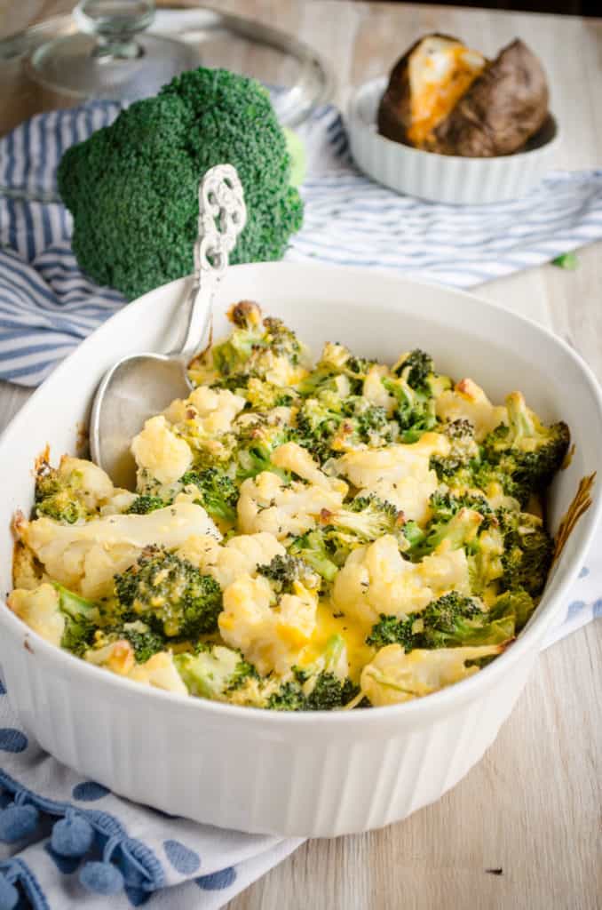 A Cheesy Cauliflower Broccoli Bake with a silver decorative serving spoon - The Goldilocks Kitchen