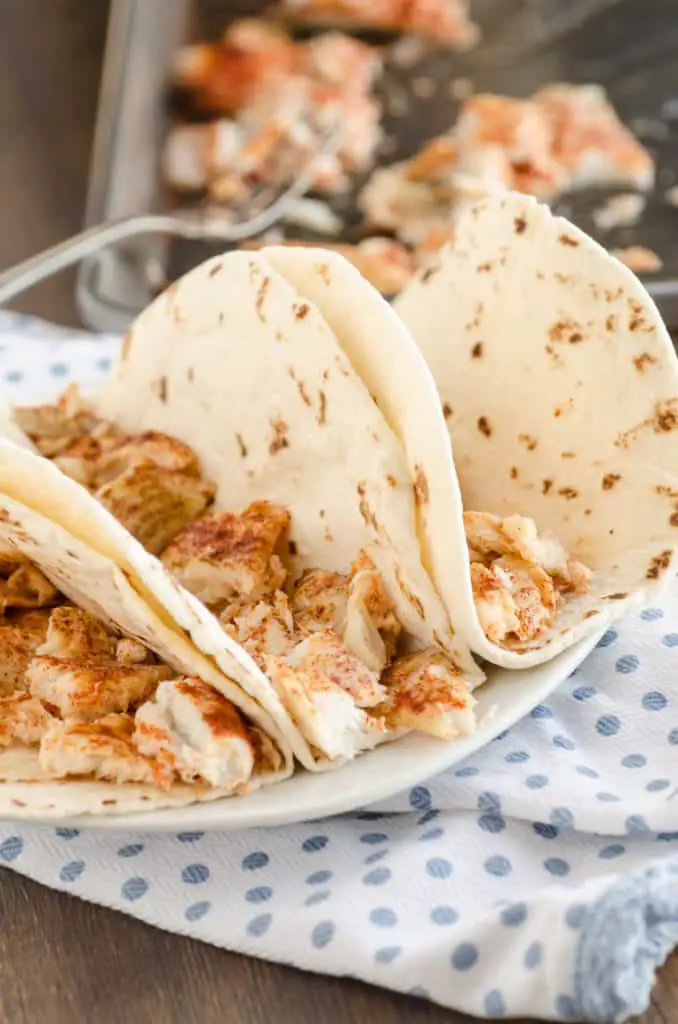 Small flour tortillas  filled with flaky taco seasoned fish for Baja Fish Tacos - The Goldilocks Kitchen