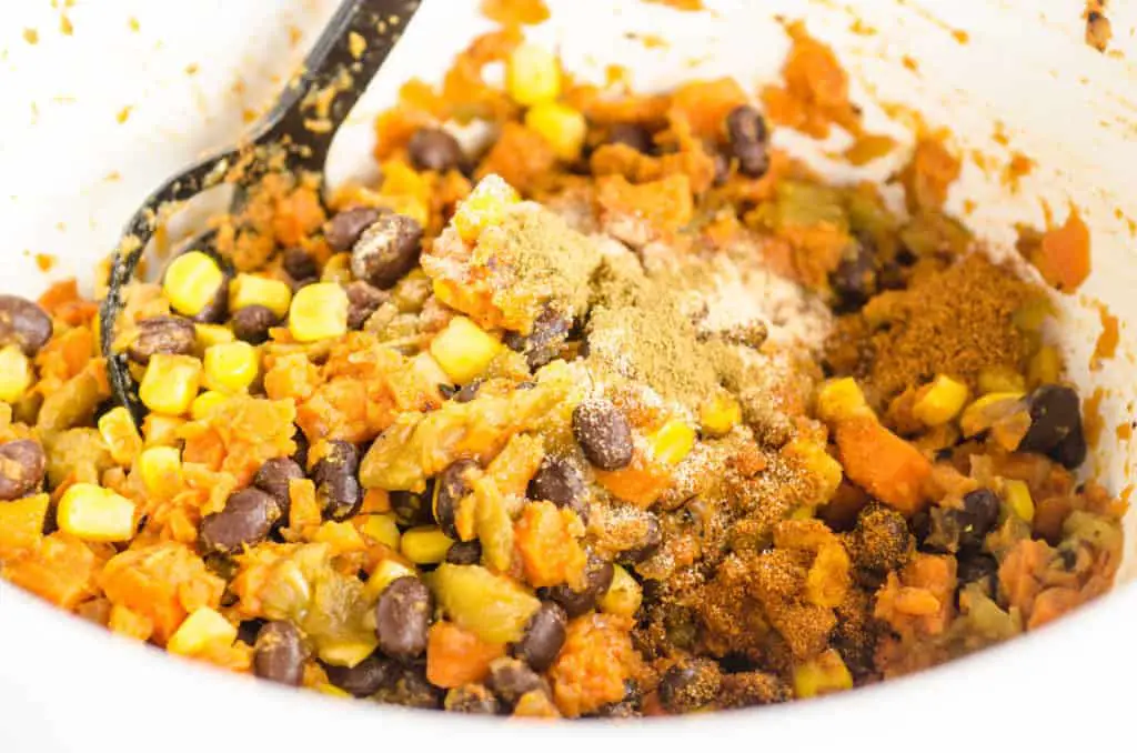 Mashed Sweet potato is mixed with black beans, green chile, corn and spices to make filling for Black Bean Sweet Potato Enchiladas - The Goldilocks Kitchen