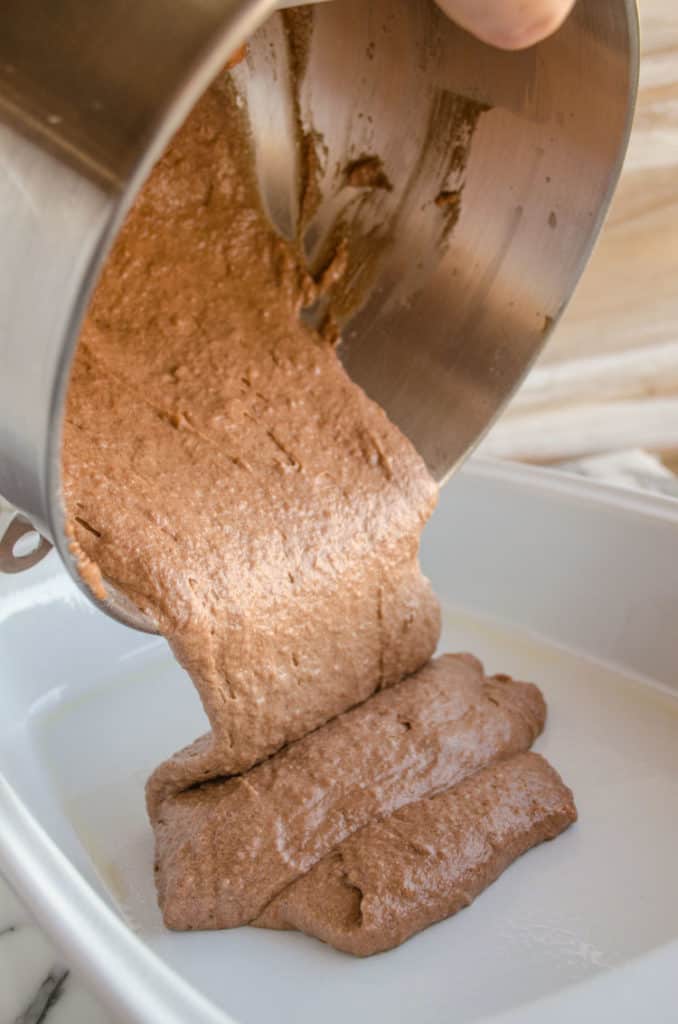 Batter is poured into a white baking dish to make Applesauce Picnic Cake - The Goldilocks Kitchen