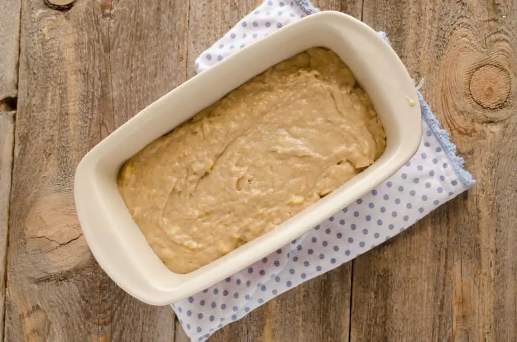 A ceramic bread pan filled with Orange Spice Banana Bread batter - The Goldilocks Kitchen 