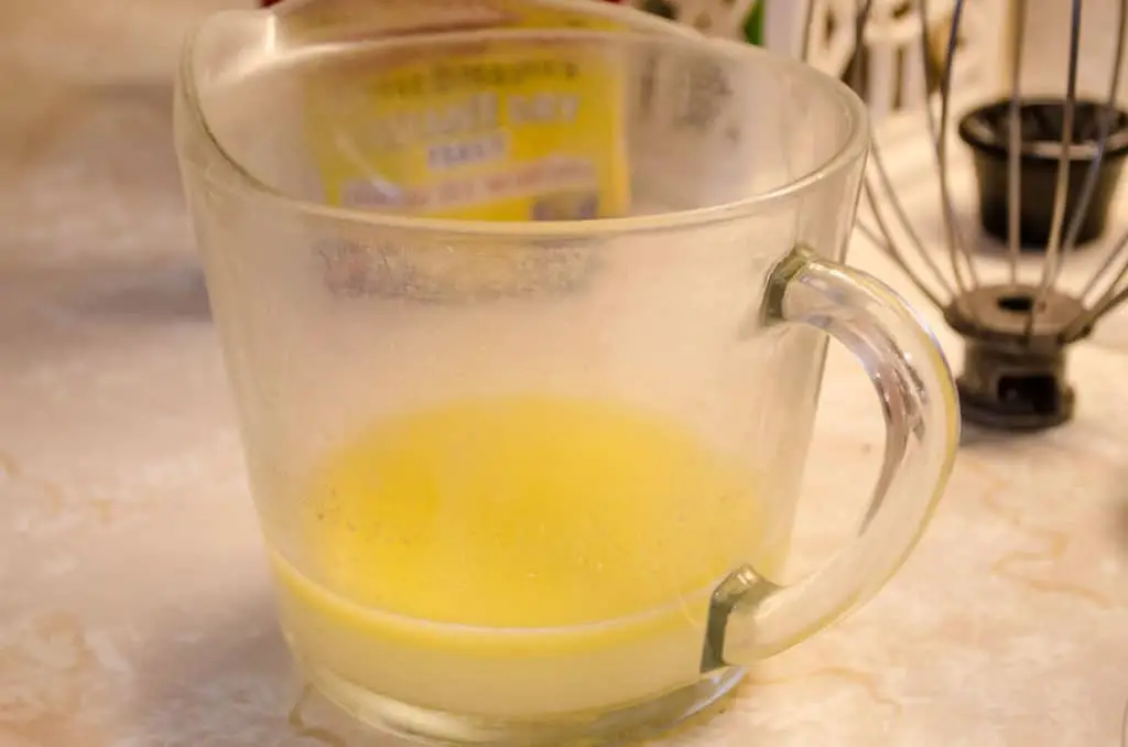 A pyrex measuring cup with melted butter and hot water mixed together to help make Braided Challah Bread - The Goldilocks Kitchen
