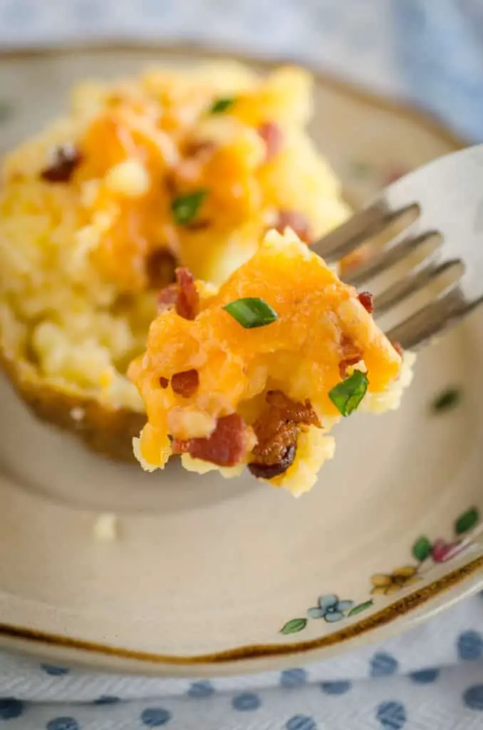 A close picture of a forkful of Make Ahead Twice Baked Potatoes with bacon, cheese and chives - The Goldilocks Kitchen