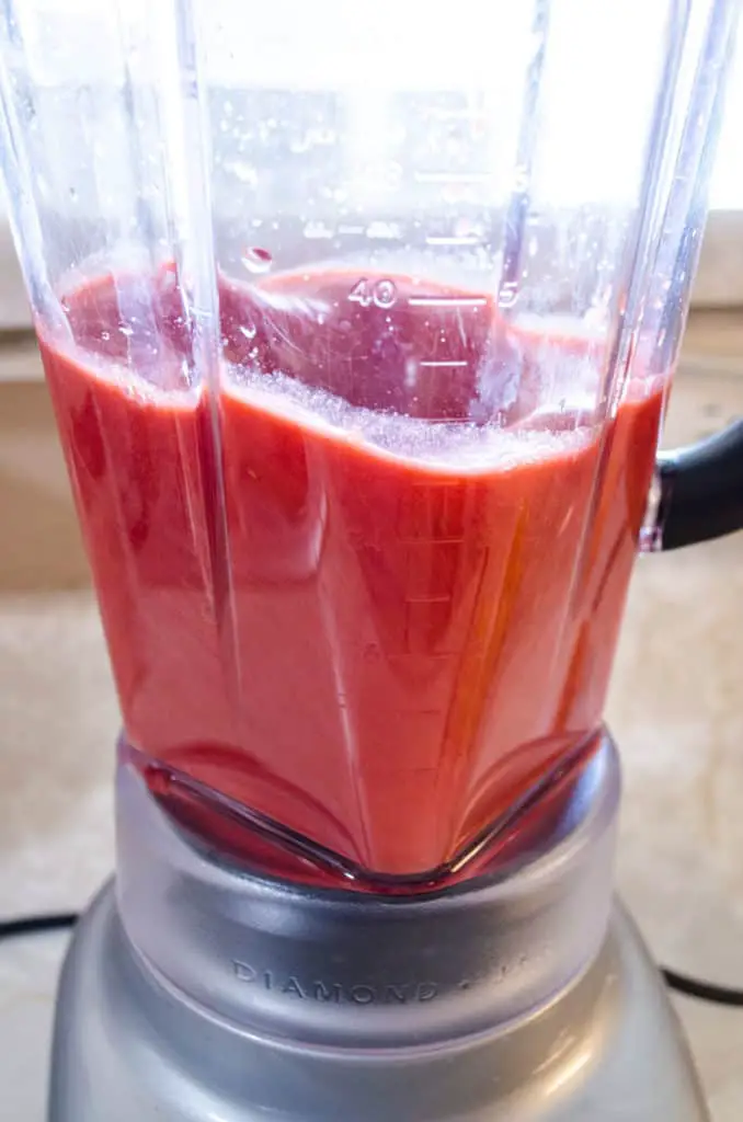 A blender whirrs with red strawberry puree for Fresh Sparkling Strawberry Lemonade - The Goldilocks Kitchen