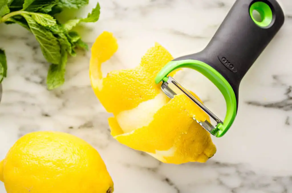 A Lemon is stripped of zest in one long spiral with the OXO Citrus Prep Peeler to make a Lemonade Sparkler - The Goldilocks Kitchen