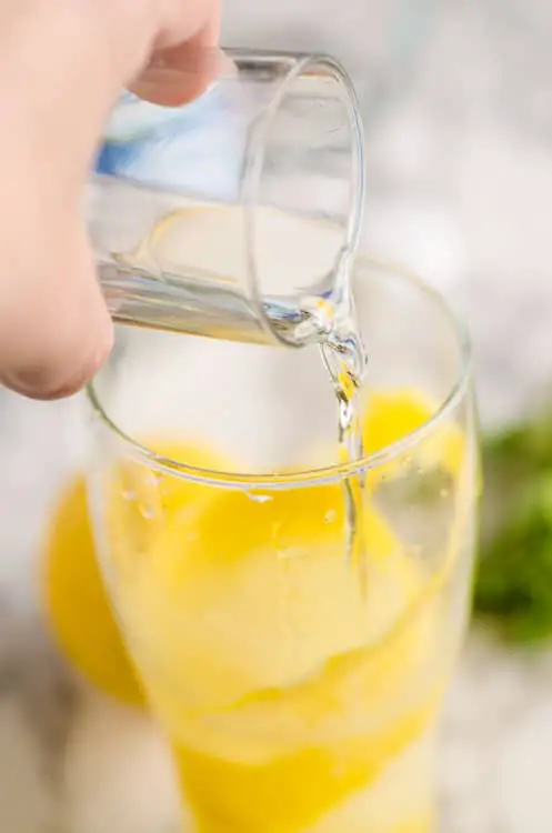 Simple Syrup is poured into a clear glass to make a Lemonade Sparkler - The Goldilocks Kitchen