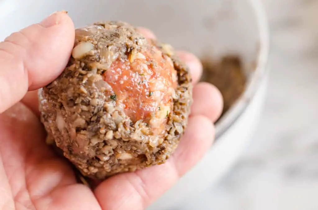 A Carrando brand Italian style meatball is covered with a thin layer of mushroom duxelles to make Easy Beef Wellingtons - The Goldilocks Kitchen