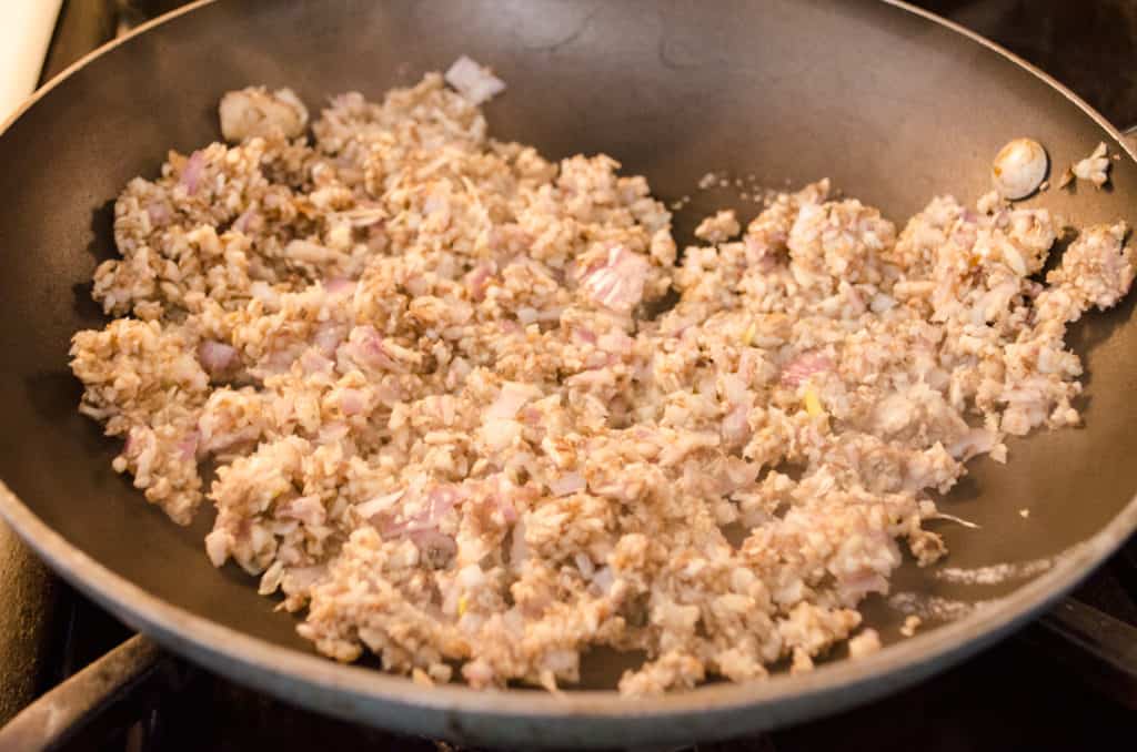 A mushroom duxelles just starting to cook down in a hot skillet to make Easy Meatball Wellingtons - The Goldilocks Kitchen