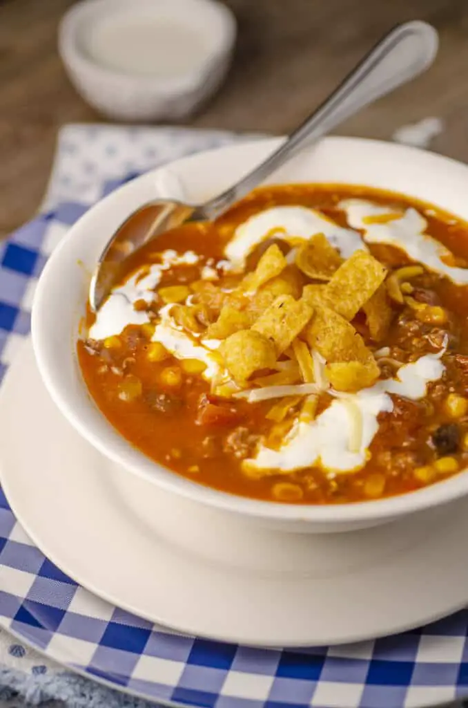 A bowl of Weeknight Taco Soup is served with a spoon.