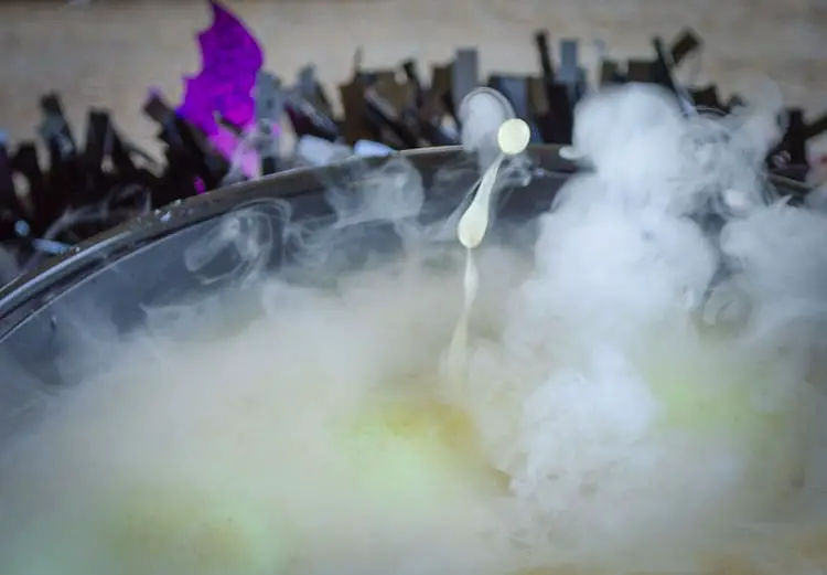 A closeup of a drop of green Witches Brew with Dry Ice being thrown into the air by the dry ice below.