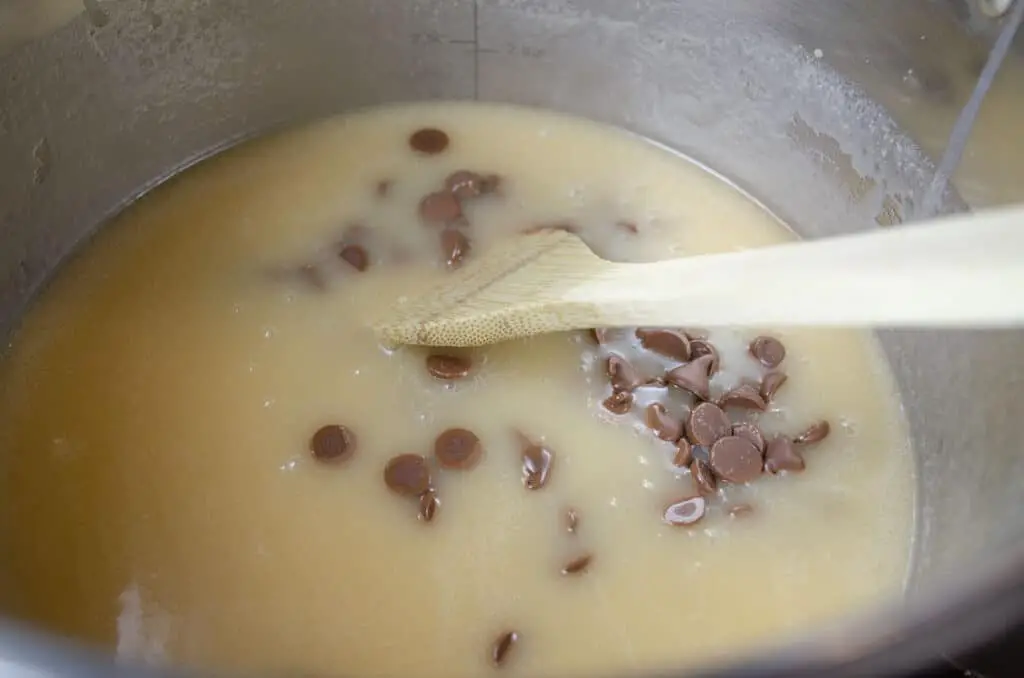 Chocolate chips floating in a mixture of sugar, butter and evaporated milk.