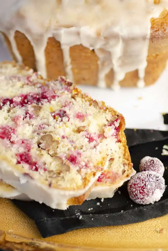 Two slices of Frosted Cranberry Nut Bread up close to show the color and texture.