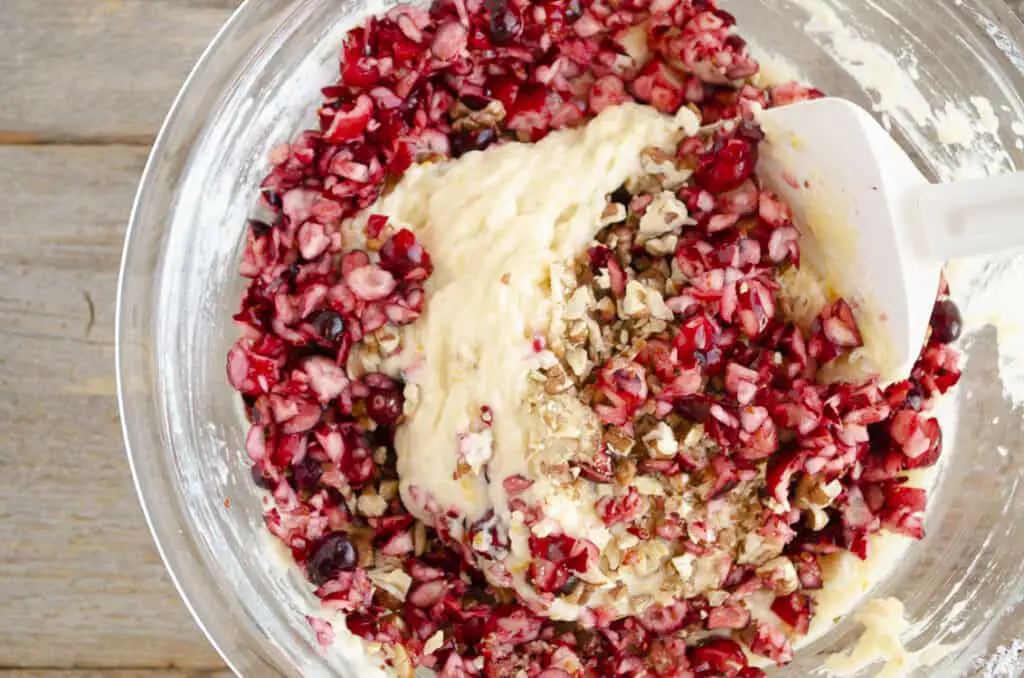 Chopped nuts and cranberries are added to bread batter to make Frosted Cranberry Nut Bread.