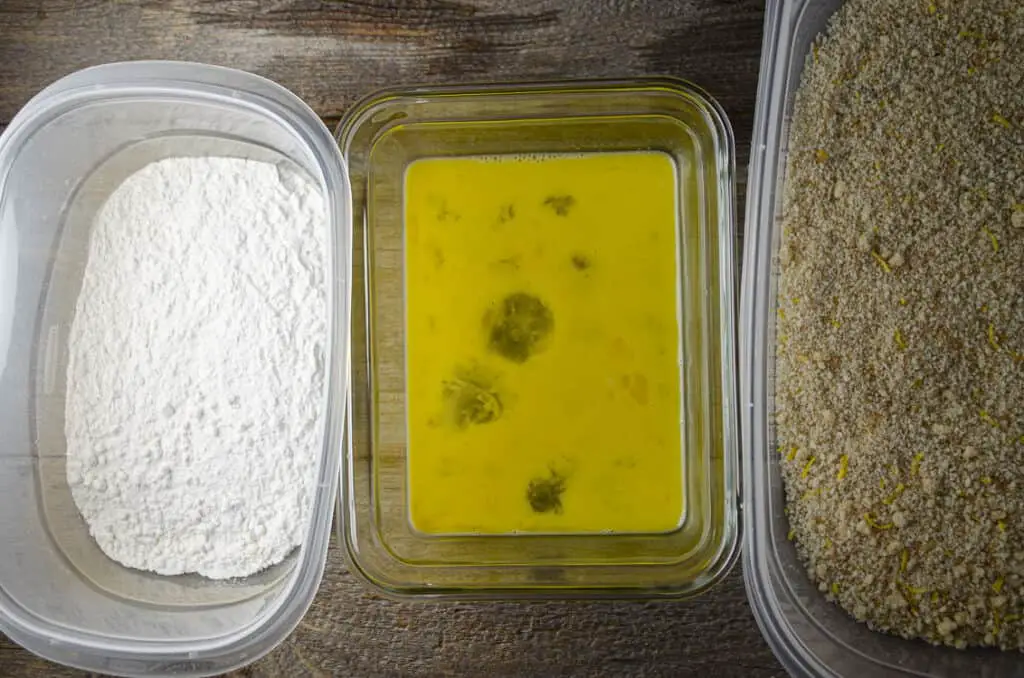 Individual containers filled with flour, beaten egg, and lemony bread crumbs for dredging Sweet Lemon Chicken Piccata.