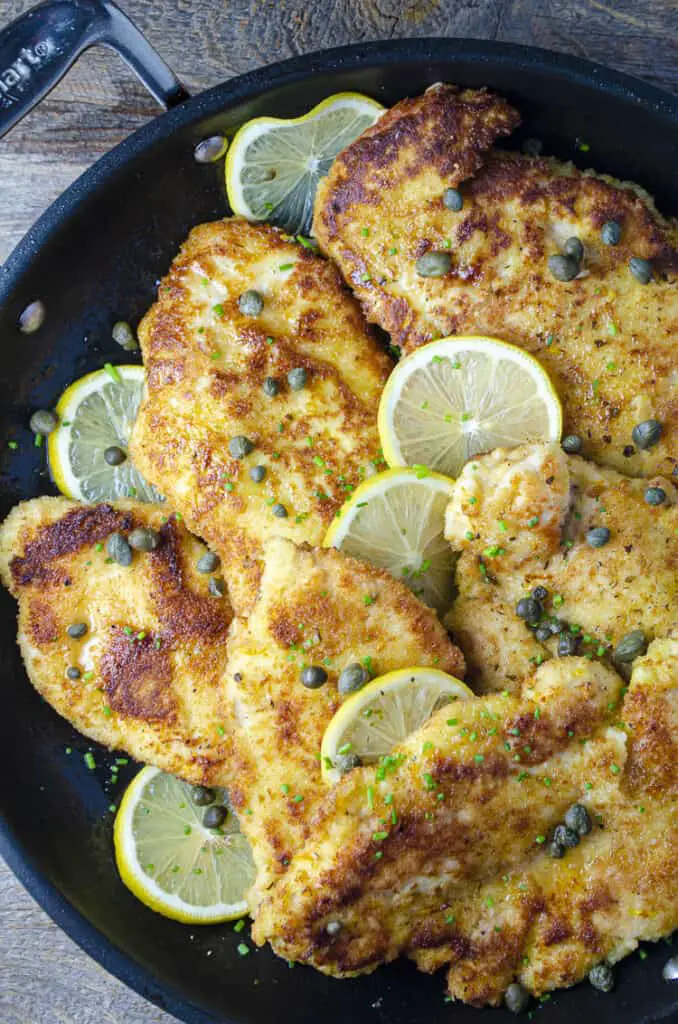 Sweet Lemon Chicken Piccata cutlets arranged with thinly sliced lemon rounds and capers, all drizzled in a sweet lemon-butter-caper pan sauce.