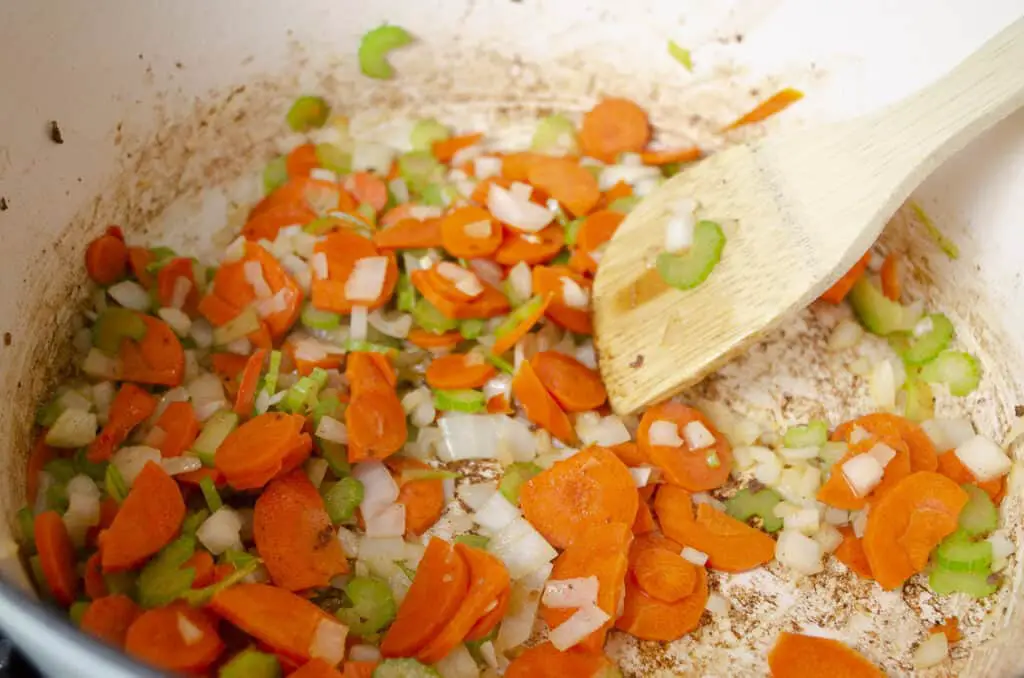 A mixture of sliced carrots, onion and celery is cooked in bacon fat.