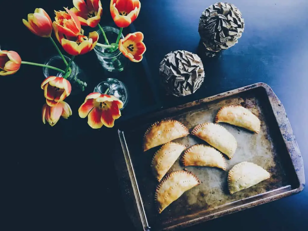Empanadas, a Latino heritage recipe, are handheld meat pies either baked or fried, filled inside with savory meet fillings like pork, chicken or beef seasoned with savory spices, tomatoes, and vegetables like potato and sometimes cheese. 