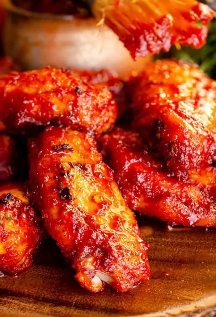 A closeup of Hatch Chile Barbecue chicken wings covered in red chile barbecue sauce.